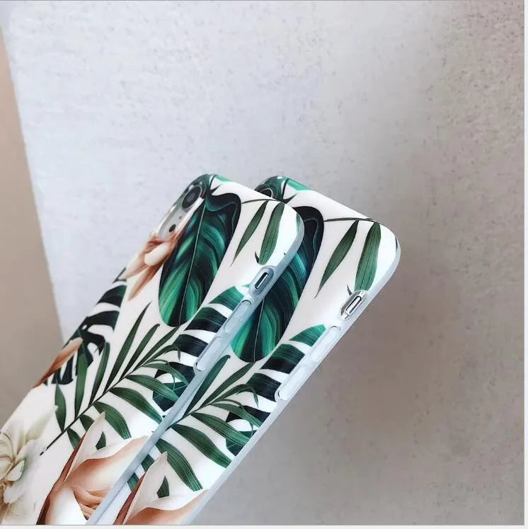 Soft TPU iPhone case with detailed floral and banana leaf art in green tones on the back.