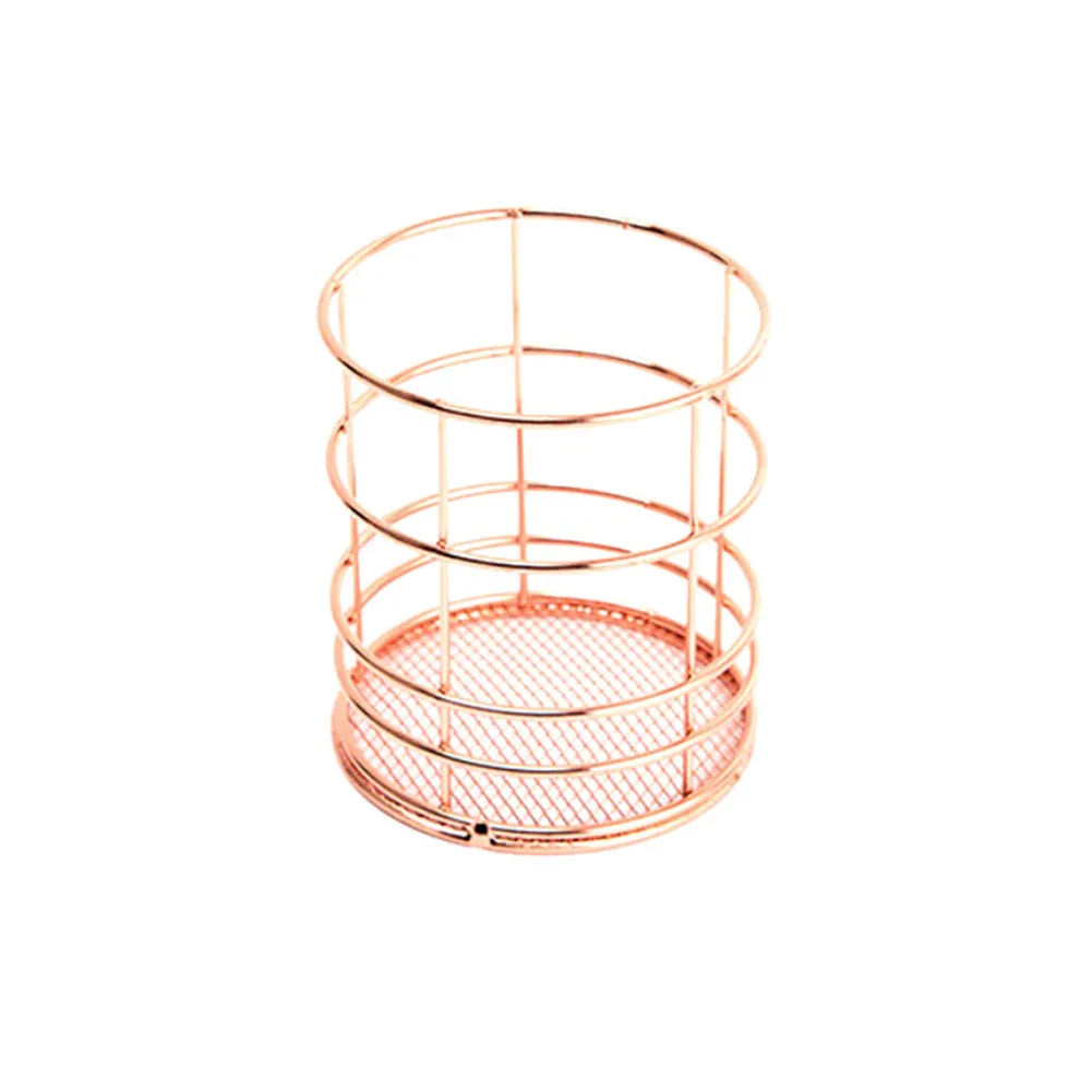 Rose gold iron wire square pen holder on desk holding pens and a ruler