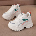 Women's white low-top sports dad shoes with cross strap and round toe, showcasing breathable mesh design.