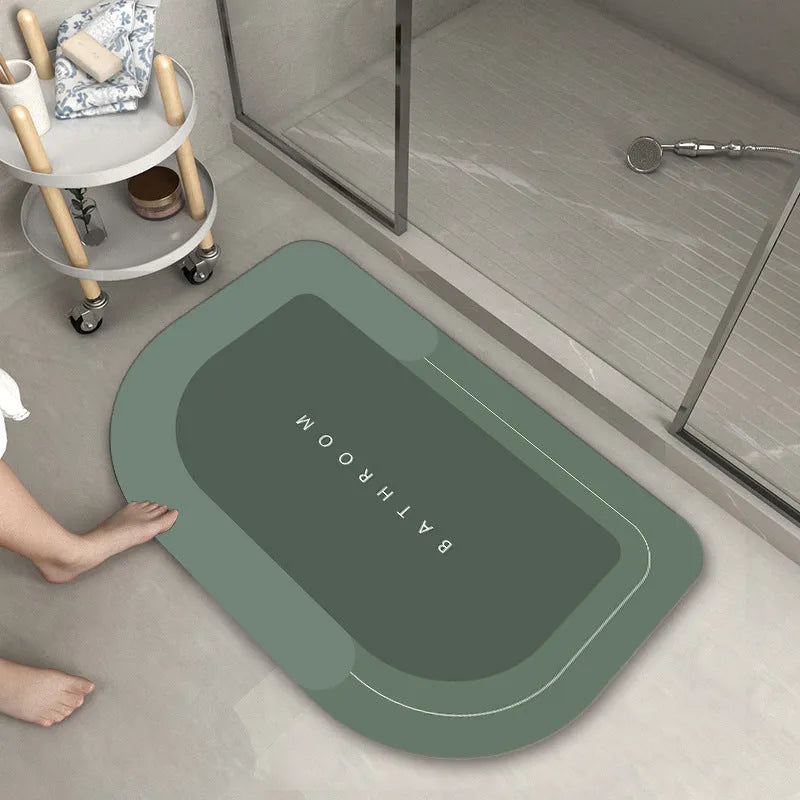 Blended fibre machine woven bathroom floor mat in blue, shown in an oval shape on a tiled floor.