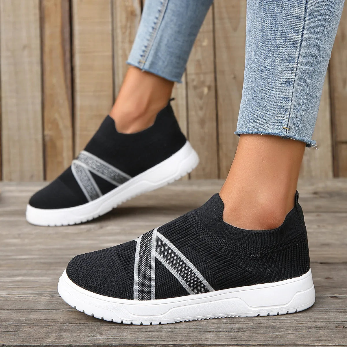 Black women's flat shoes with flyknit mesh upper, round toe, and tassel detail