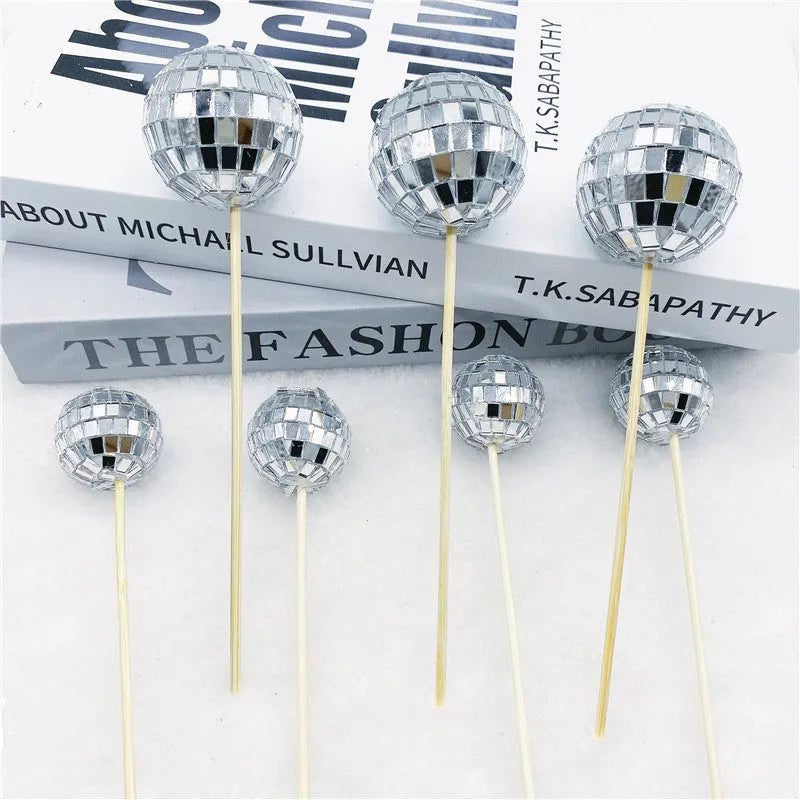 Glass disco ball cake decoration with wooden stick on a celebration cake