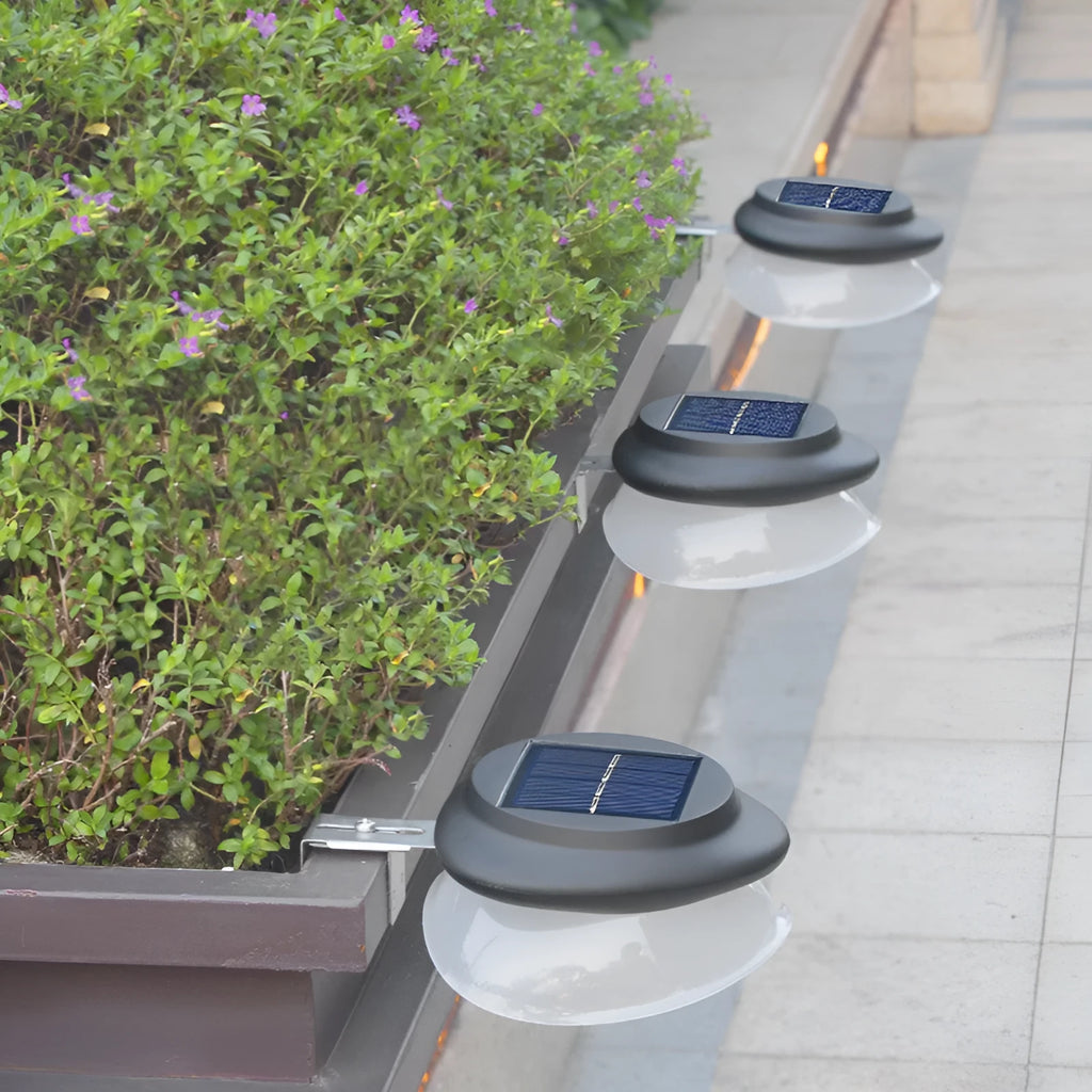 Solar-powered outdoor garden wall lamp with Southeast Asian design on fence