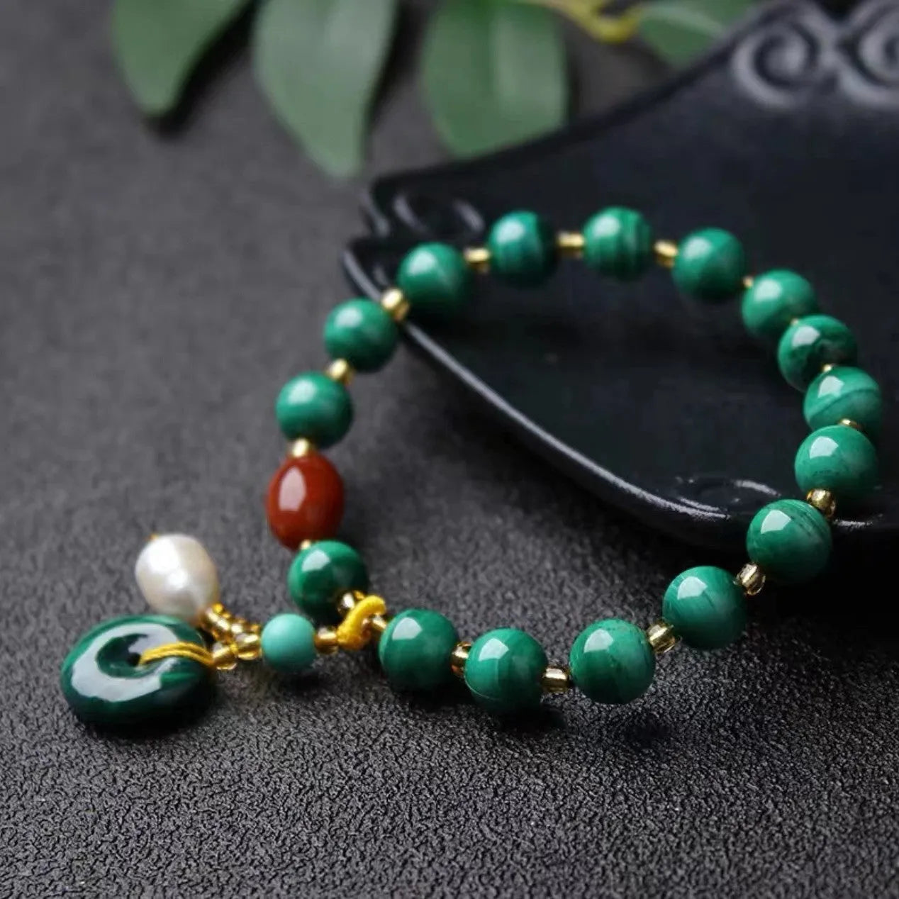 Natural green malachite bracelet with barrel-shaped beads on a wrist.