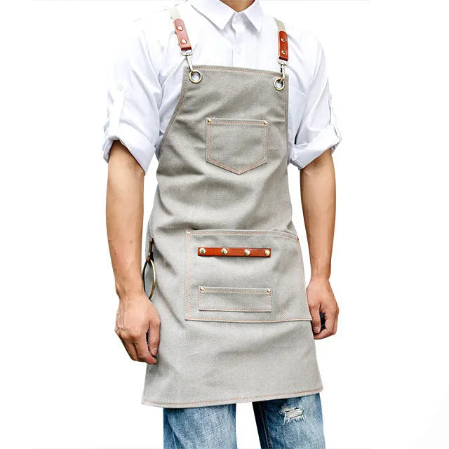 Canvas cross-strap apron in camel colour on hanger