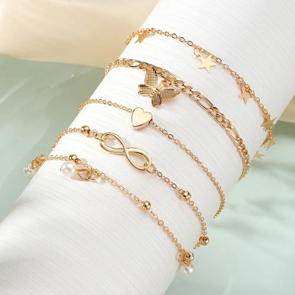 Four-piece women's anklet set with butterfly and pearl heart designs in alloy