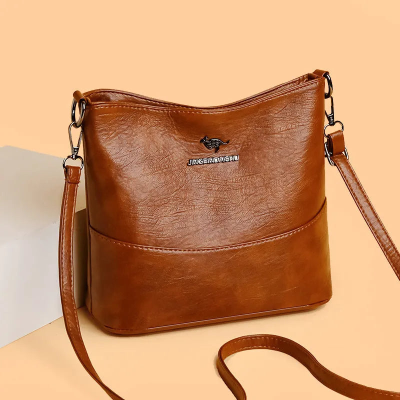 Women's casual soft leather bucket shoulder bag in black, wine red, or ginger yellow, showing large capacity and minimalist design.