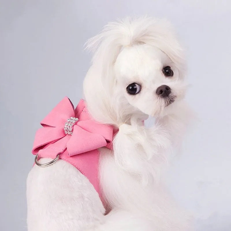 Pink microfiber dog harness with a large bowknot on the chest, shown alongside blue and orange colour options.
