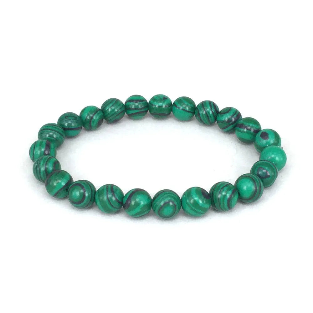 Malachite green and black matte 8mm round bead elastic strand bracelet on a neutral background
