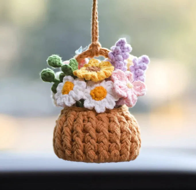 Green and white knitted wool car plant ornament with basin base and hanging rope.