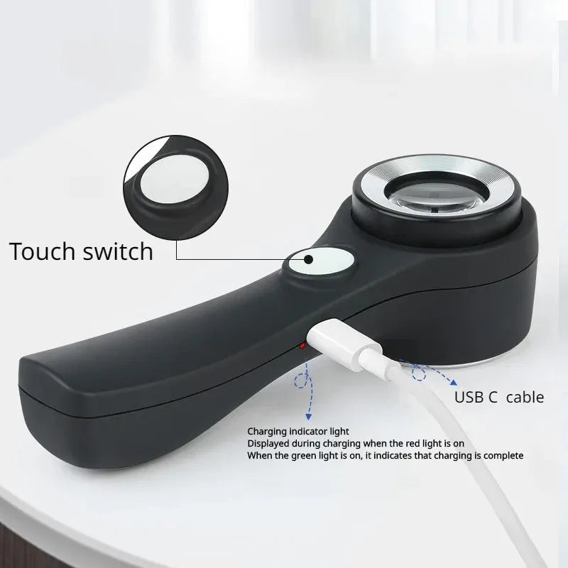 Black metal jeweller's loupe magnifying glass with adjustable stand on a wooden desk.