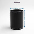 Small round black leather pen container on a desk