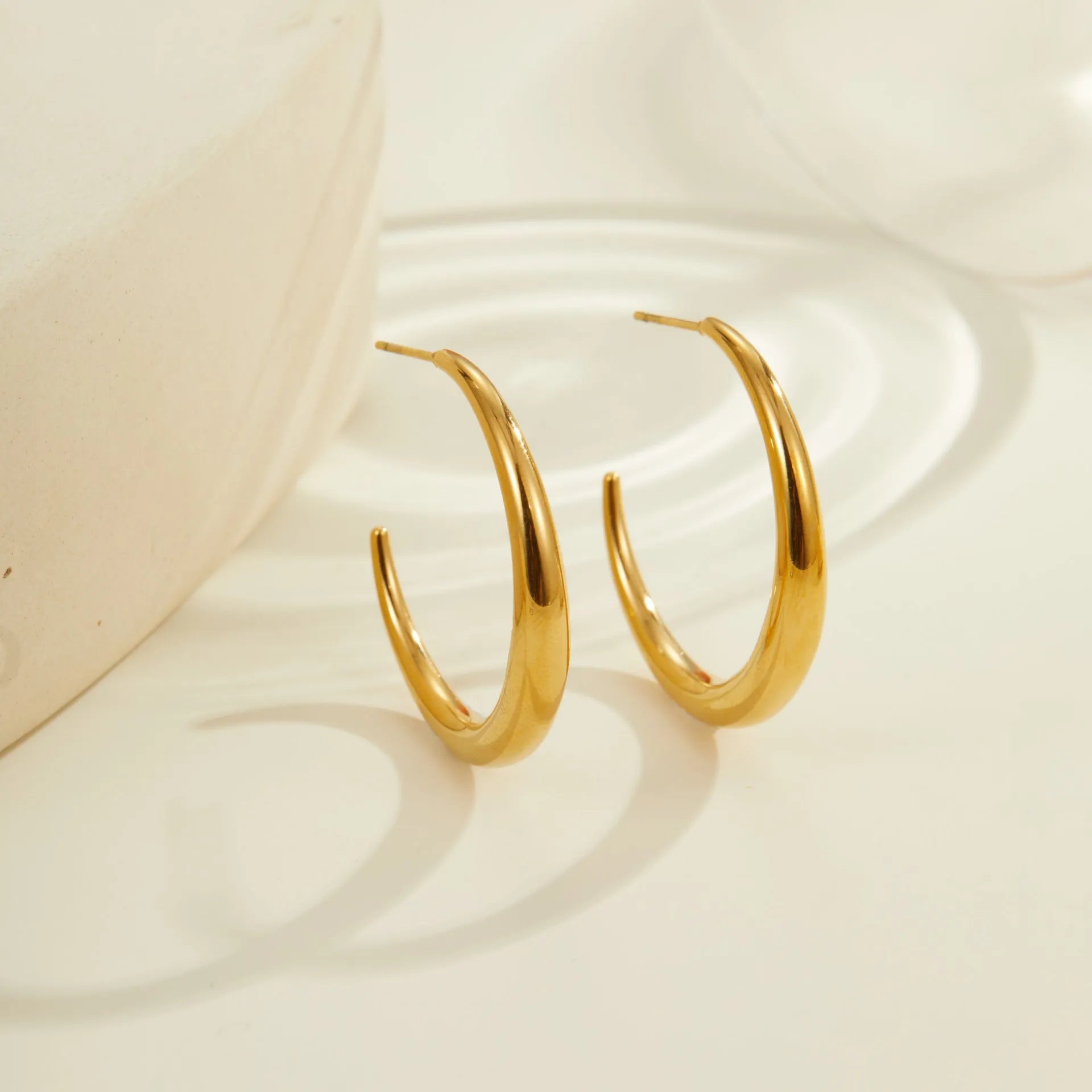 Titanium steel hoop earrings in geometric round design with gold or steel finishes