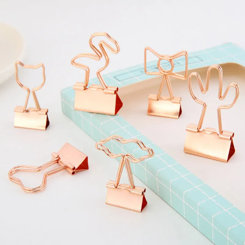 Golden metal stationery clip with a decorative flamingo design on a long tail.