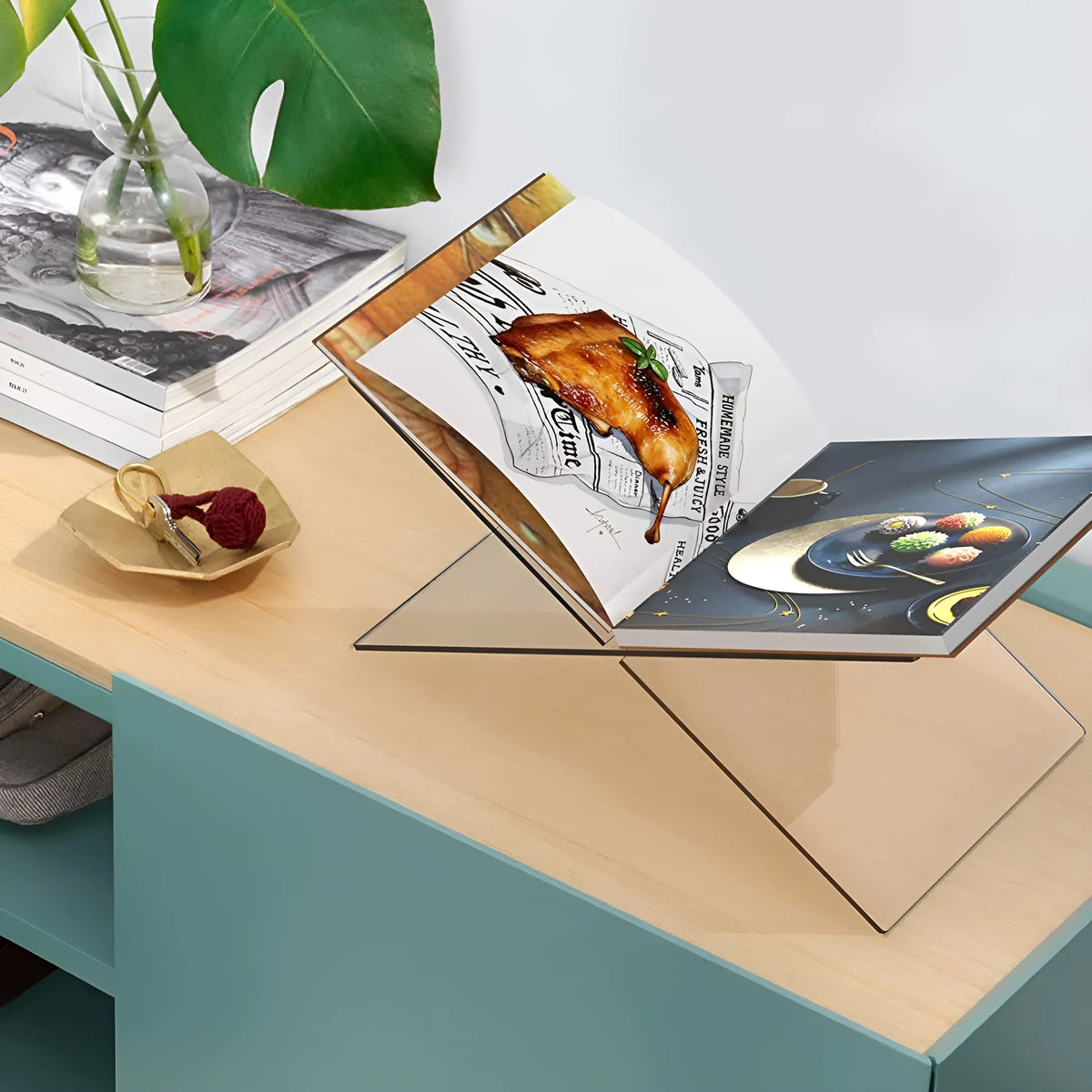 Clear acrylic X-shaped desktop book display rack holding a book.