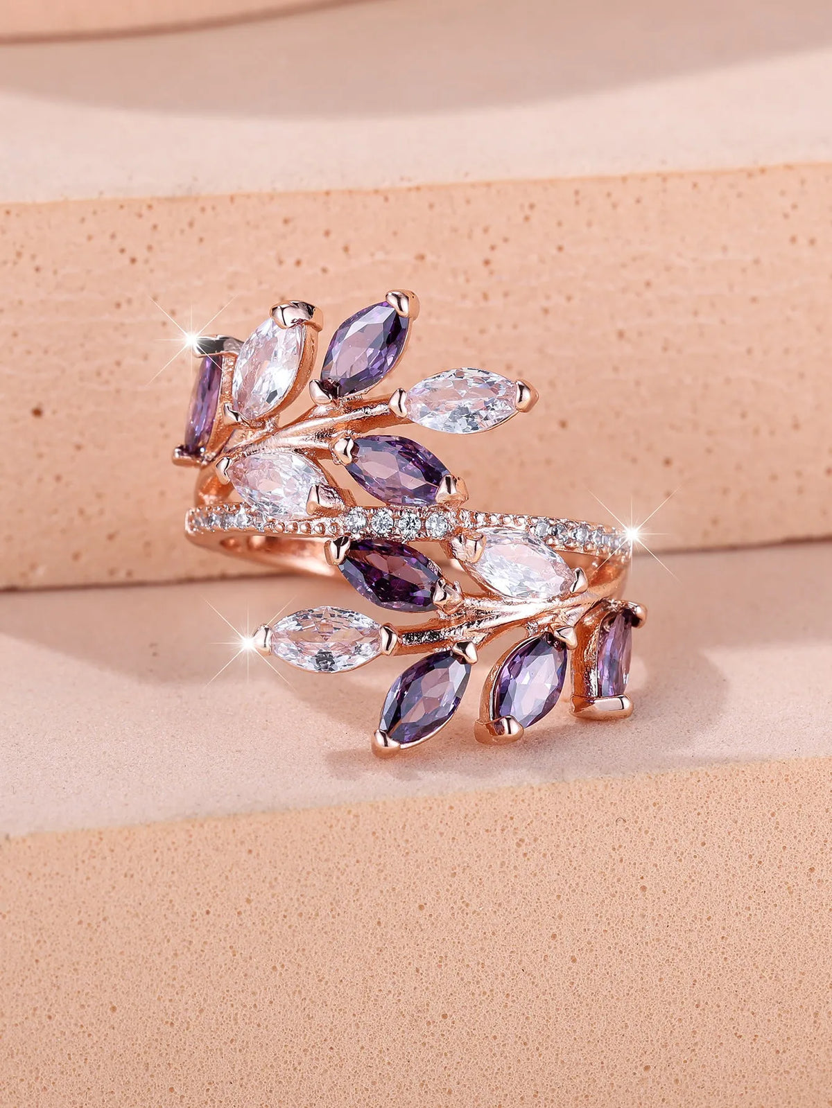 Adjustable copper leaf ring in platinum or rose gold finish on a white background