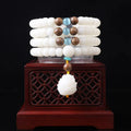 White jade Bodhi seed bracelet with 6x8mm beads in multiple styles including lotus and cloisonne designs.
