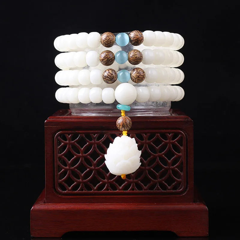White jade Bodhi seed bracelet with 6x8mm beads in multiple styles including lotus and cloisonne designs.