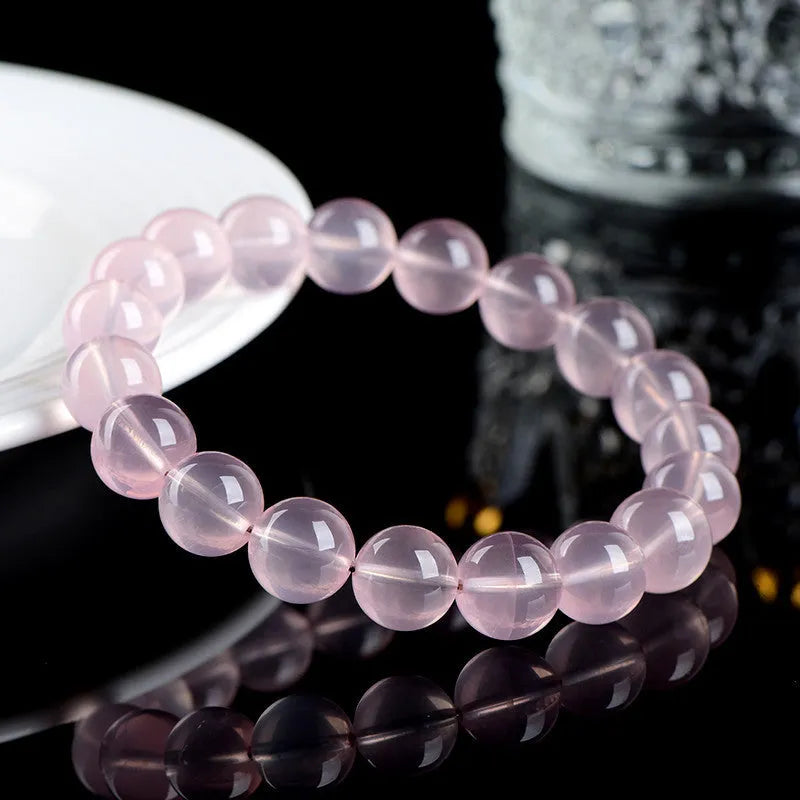 Polished natural crystal bracelet with round pink beads in starlight style, showing colour and size options.