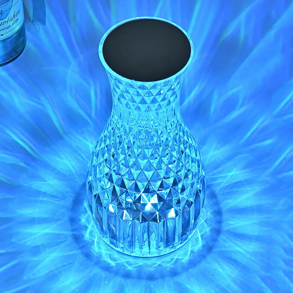 Crystal vase-shaped table lamp with remote control on wooden bedside table