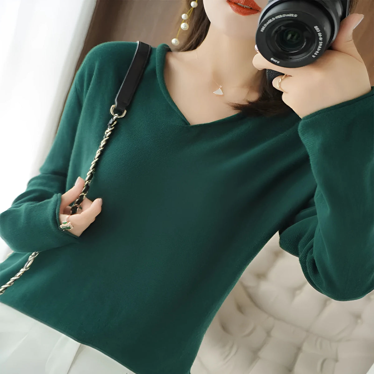 Women's long sleeve V-neck knitwear top in turmeric colour, laid flat to show pullover style and non-ironing fabric.