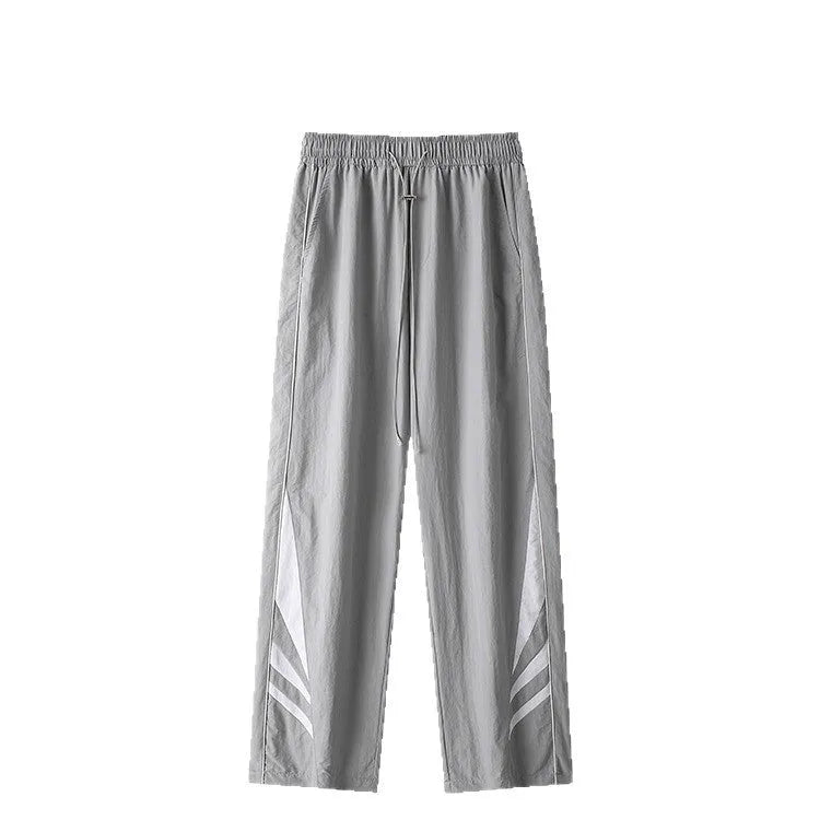 Man wearing grey straight-leg casual trousers with a button fly and elasticated waist.