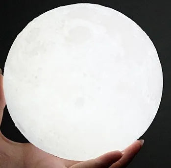 3D printed white moon lamp on a wooden stand with touch-control ring at base