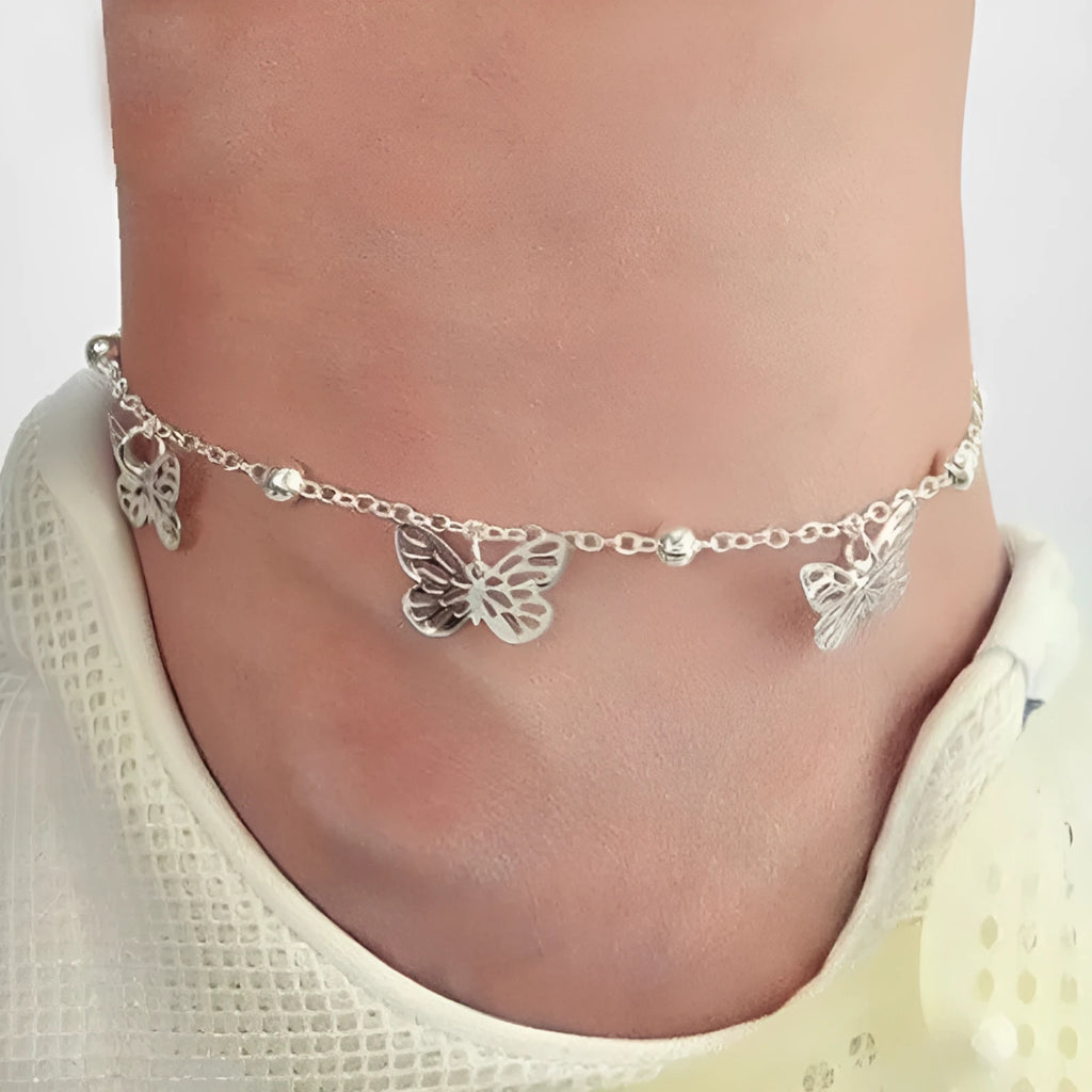 Alloy hollow butterfly design anklet in gold finish on a woman's ankle, beach foot ornament style
