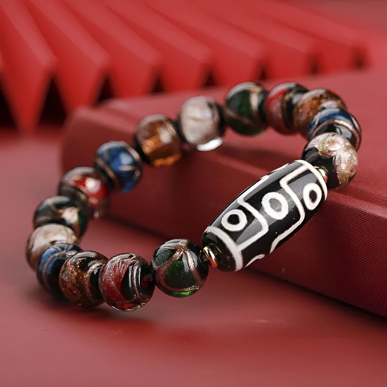Close-up of a Chinese style coloured glaze bead bracelet with auspicious patterns, showing bead sizing options.