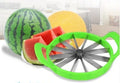 Green watermelon slicer with 410 stainless steel blade and non-slip handle on table
