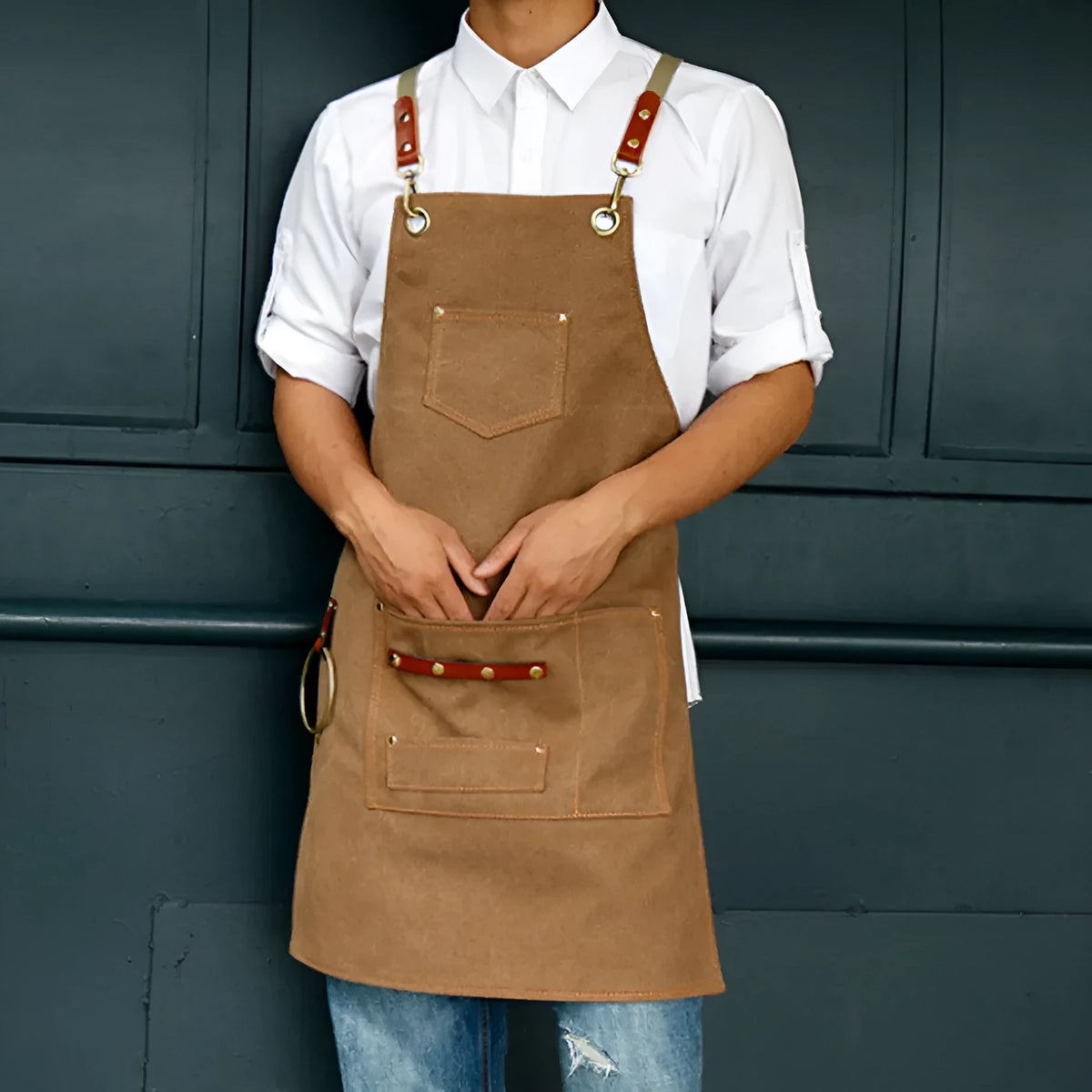 Canvas cross-strap apron in camel colour on hanger
