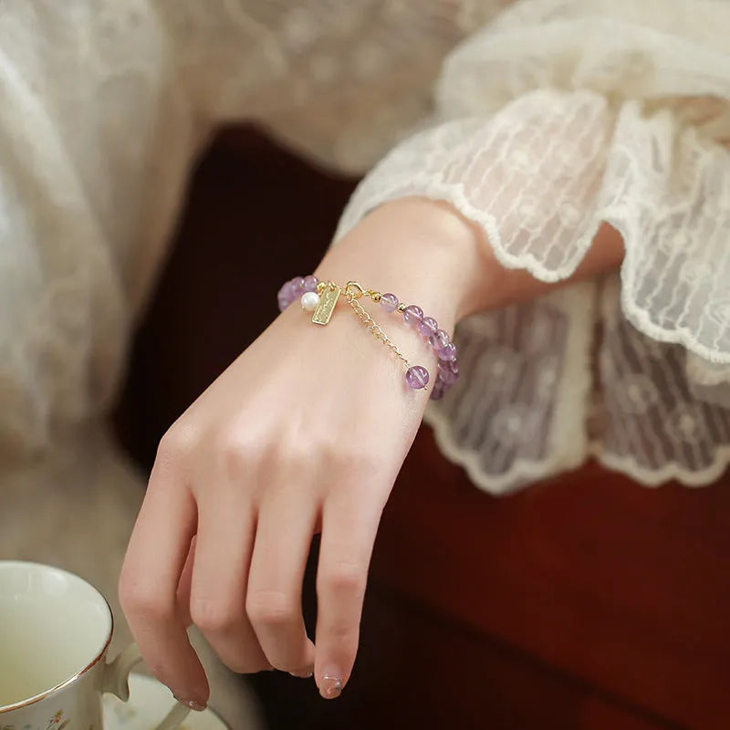 Women's natural crystal bracelet with lavender amethyst stones and animal zodiac design.