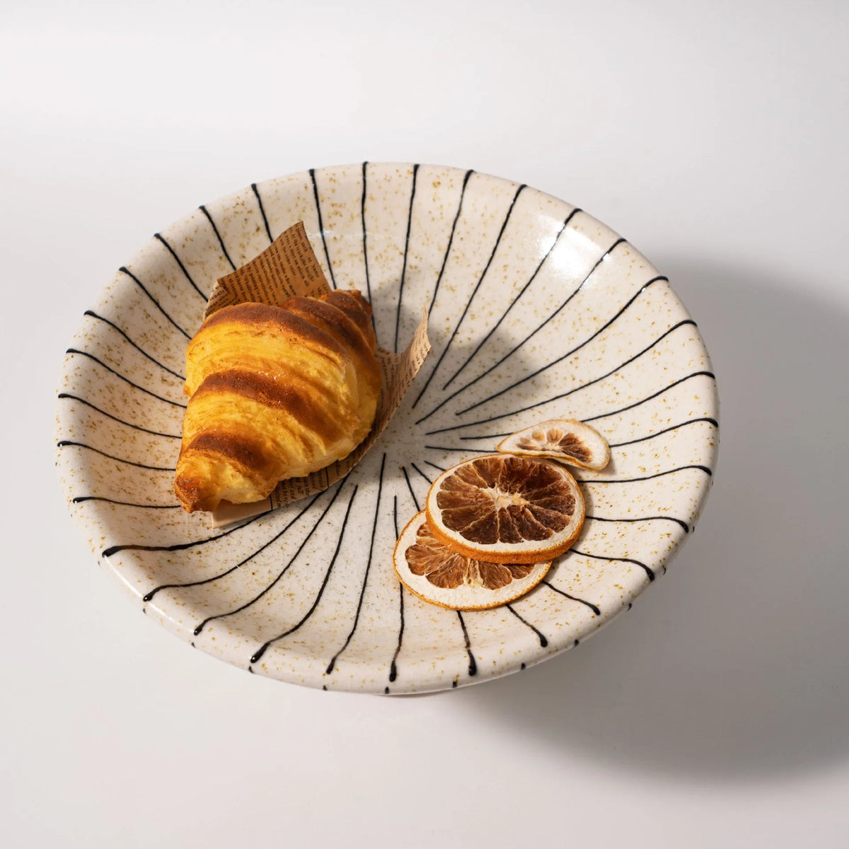 Black and white striped retro fruit plate on table with dessert