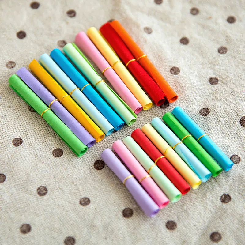 Assorted coloured paper scrolls in small sizes with a metal eyelet for hanging.