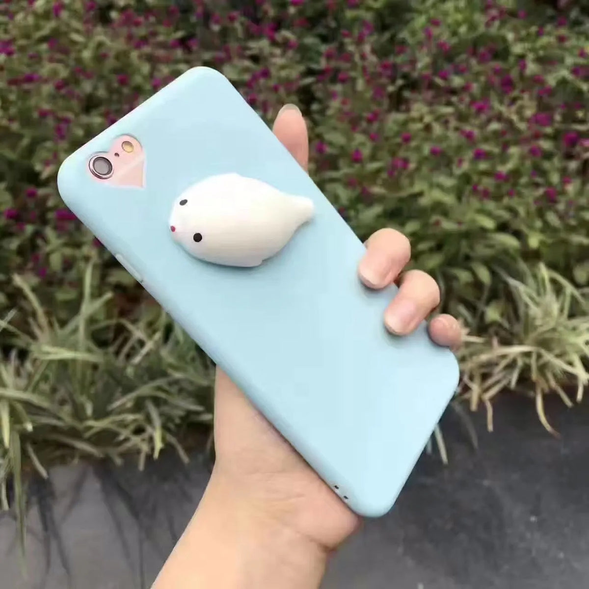 Soft pink silicone TPU phone case with a raised 3D cartoon cat design on the back, fitted to an iPhone.