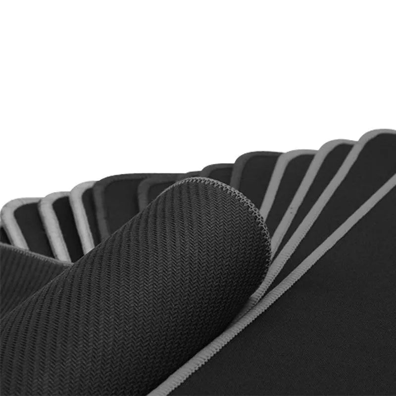 Extra long black mouse pad with stitched edges on a desk showing keyboard and mouse placement