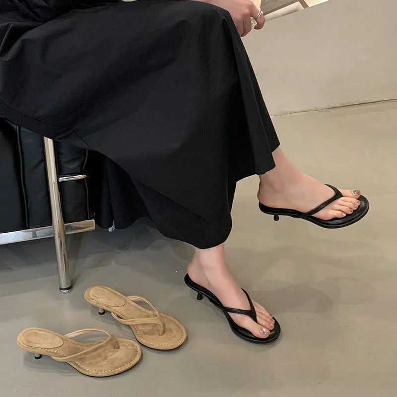 Women's black rubber flip-flop sandals with stiletto heel and round toe on a white background