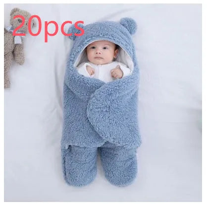 A baby quilted sleeping bag wrapper in a cotton blend fabric, shown in a light blue colour, laid flat.