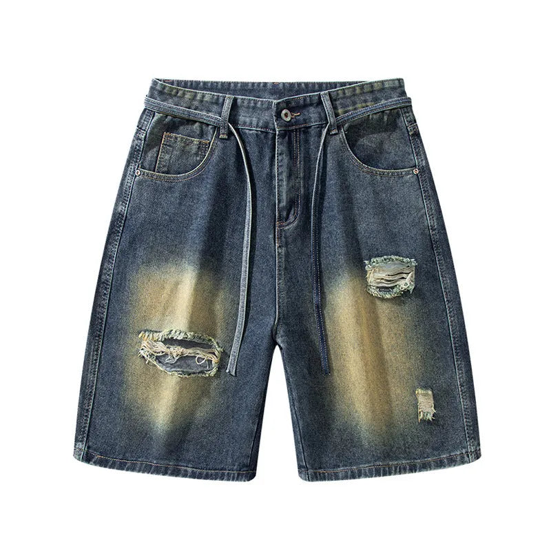 Man wearing loose fit retro blue ripped jeans with distressed details on knees and thighs