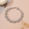 Gold and silver flower bracelet with colourful crystal and simulated diamond stones on a wrist.