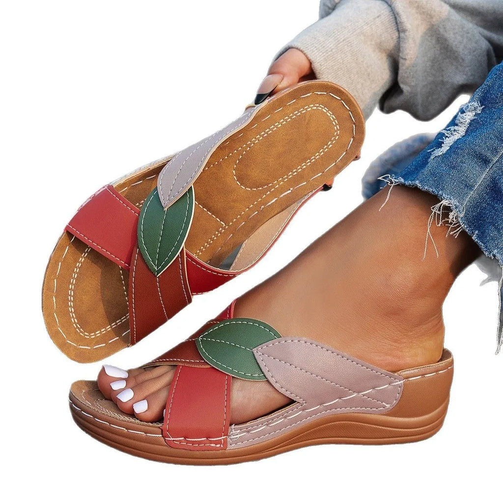 Women's black thick-soled slippers with cross-straps and a peep-toe opening on a white background.