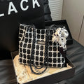 Wool blend shoulder bag in horizontal square shape with organisational compartments and woven sewing details