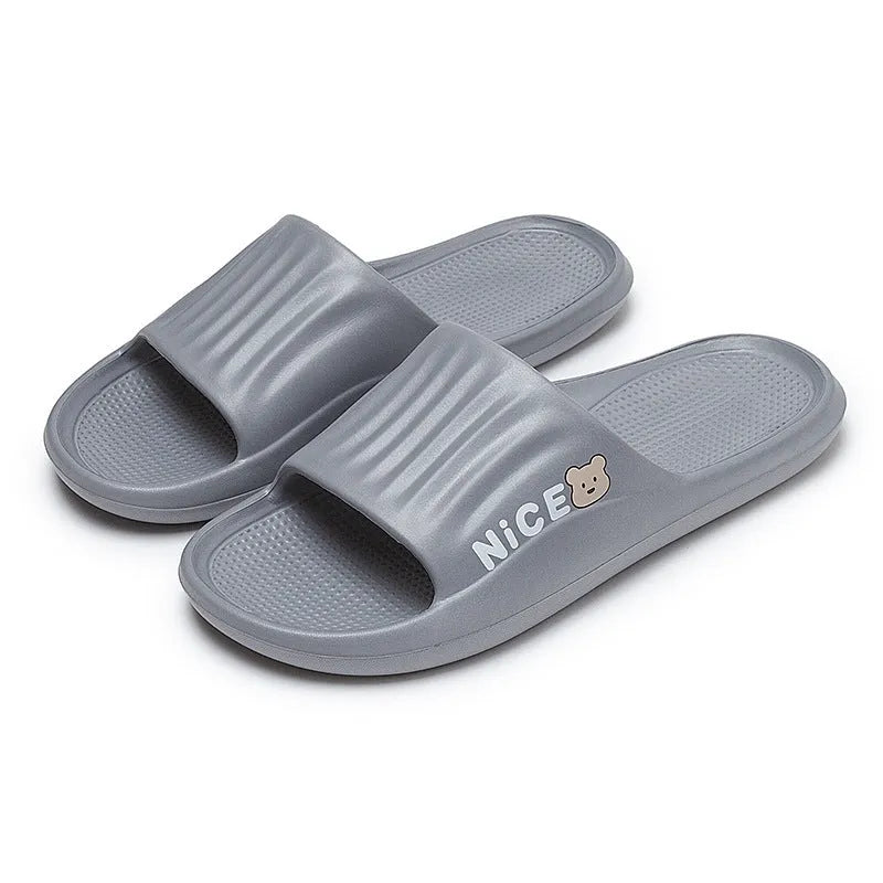 Pair of lightweight EVA flip-flop slippers with a minimalist cartoon pattern and non-slip soles.