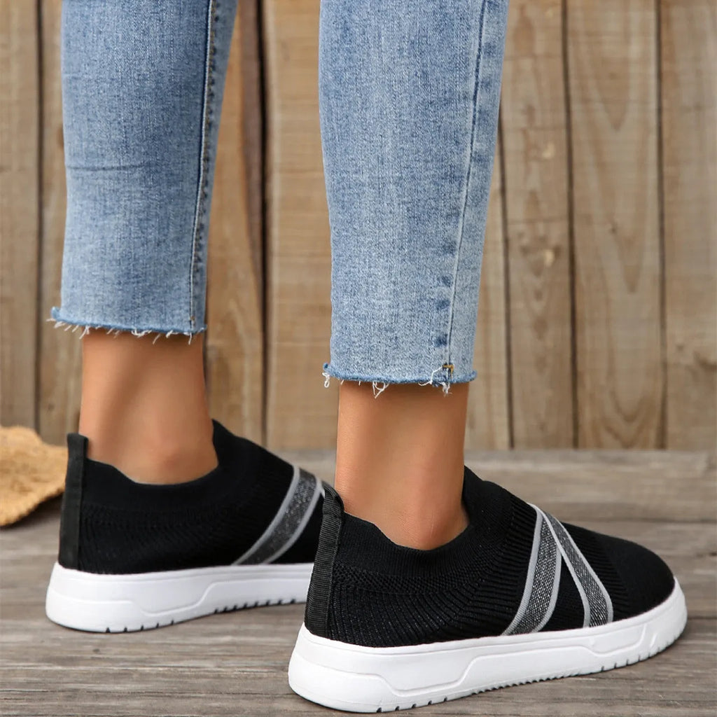 Black women's flat shoes with flyknit mesh upper, round toe, and tassel detail