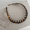 Women's acetate fibre toothed hair hoop in black colour, showing non-slip wave pressure nozzle and irregular Korean-style shape.