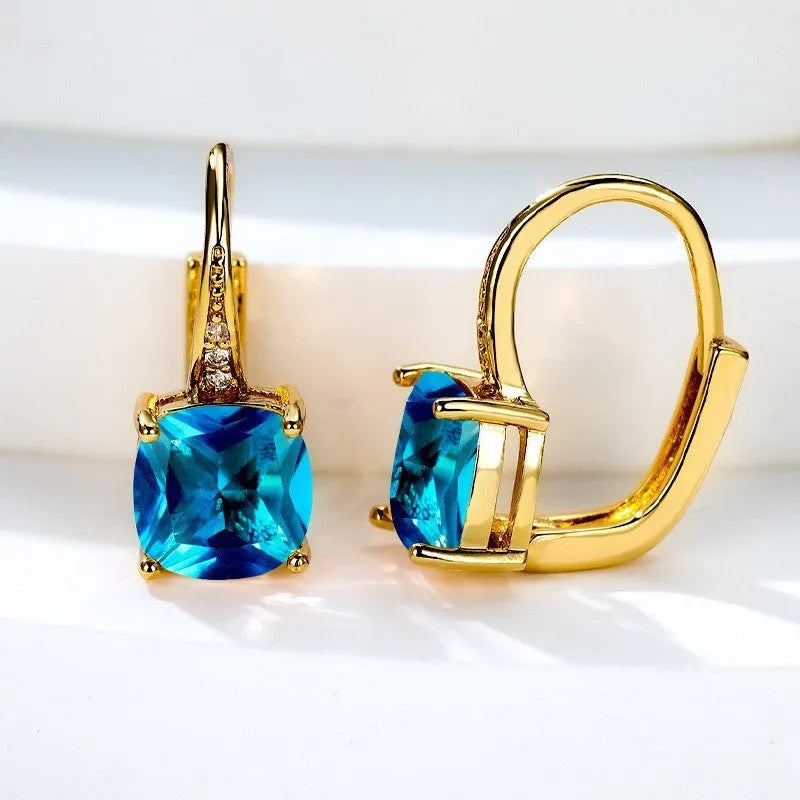 Geometric copper ear hook earrings with a round square zircon inlay, shown in a gold electroplated finish.