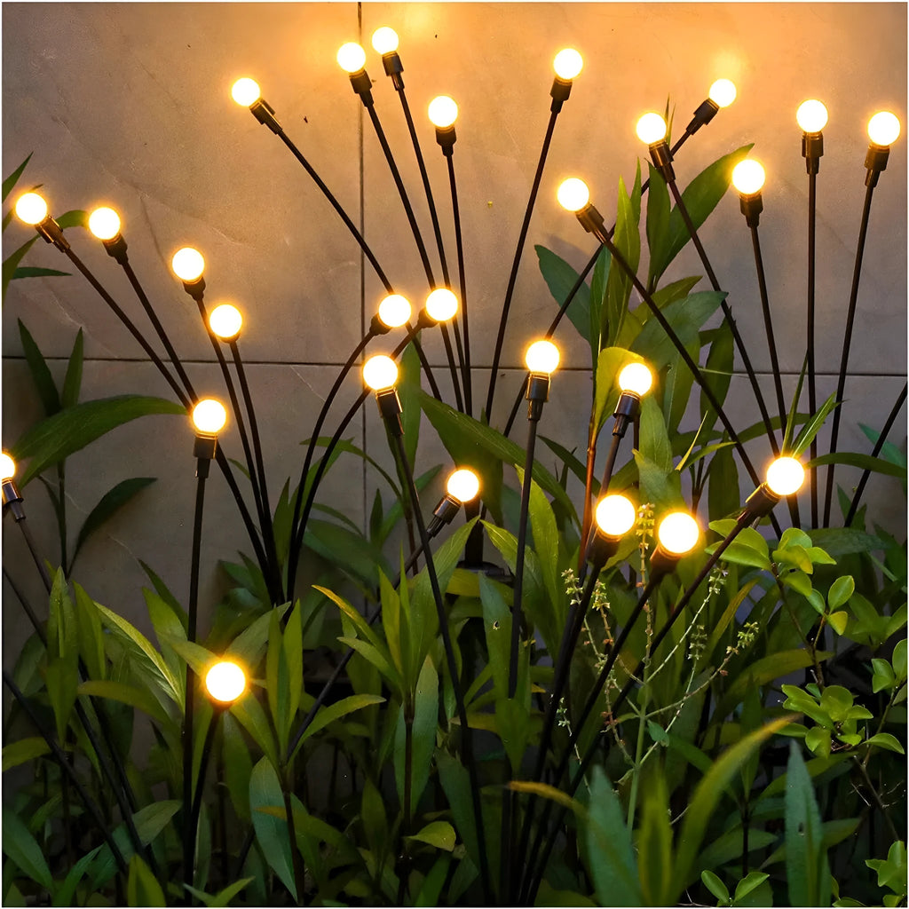 Solar-powered LED garden lamp with multiple light heads and ground plug stakes on a lawn