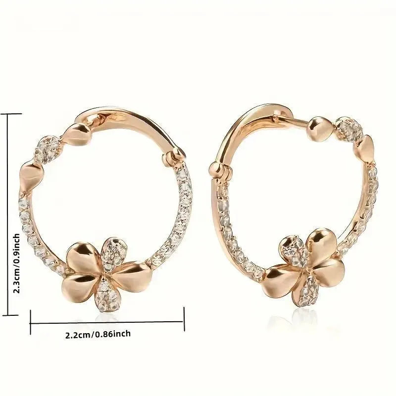 A pair of round gold-coloured hoop earrings with a geometric ring design on a plain background.