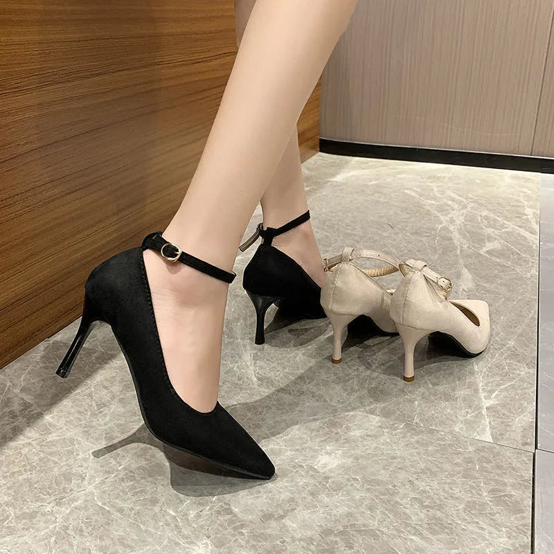 Black and creamy white women's stiletto heel pumps with a skull pattern and ankle buckle.