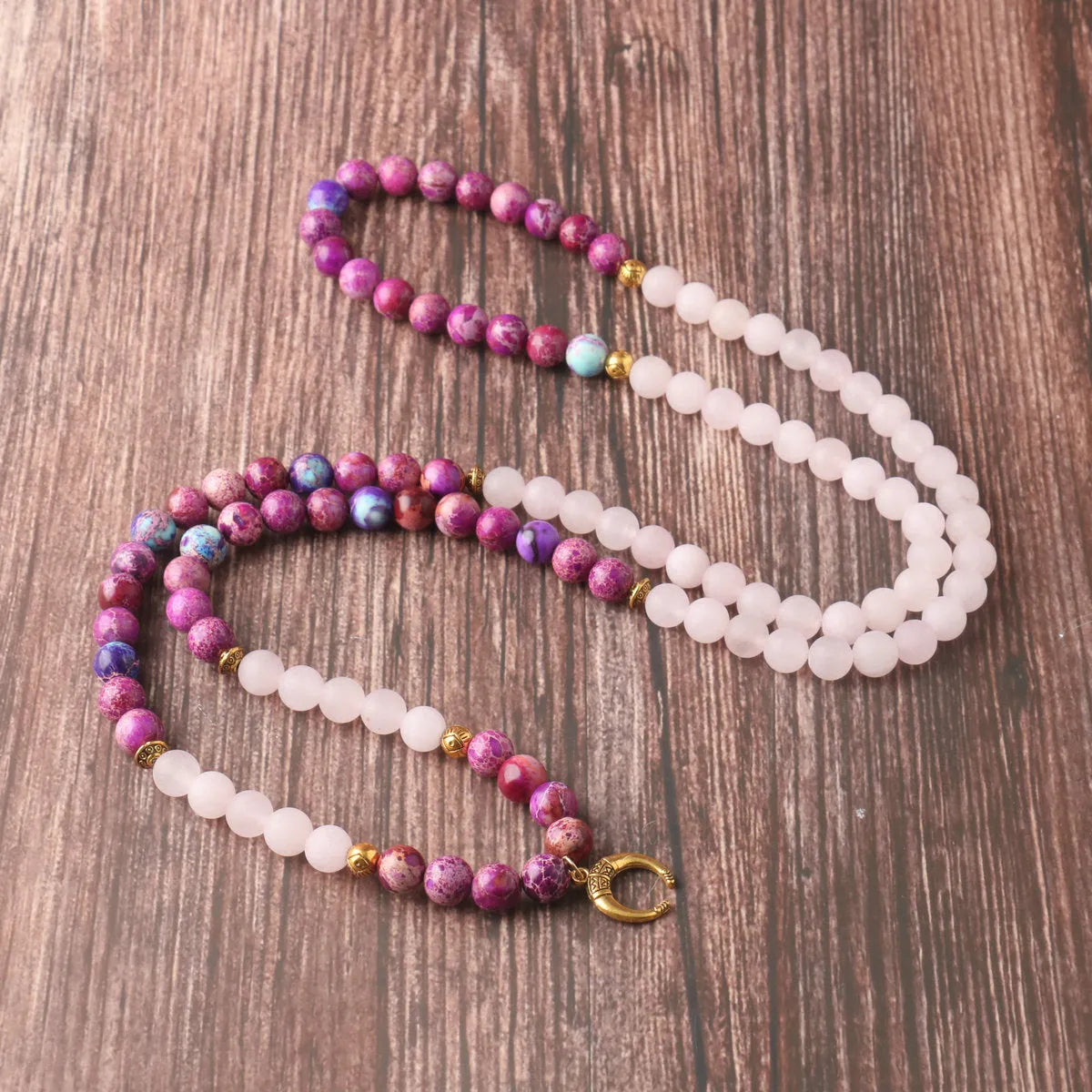 Close-up of a pink emperor stone crystal bead pendant on a necklace chain for casual wear.